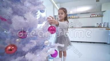 漂亮的小女孩走到最前面的圣诞树上，在树枝上放了一个玻璃杯。